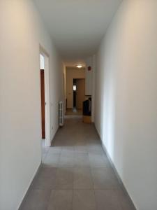 un corridoio vuoto con pareti bianche e pavimento piastrellato di Bed and breakfast Settesette6 a Barghe