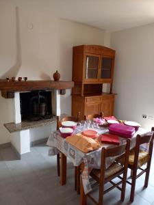 una sala da pranzo con tavolo, sedie e camino di Bed and breakfast Settesette6 a Barghe