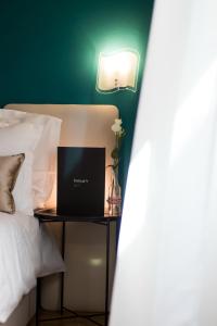 a bed with a laptop on a table next to it at Boutique Hotel Bura 45N in Senj