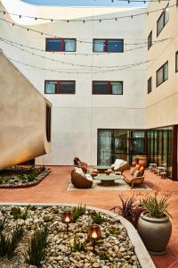 a courtyard in a building with chairs and tables at Alsace LA in Los Angeles