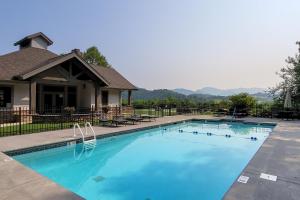 a large swimming pool with blue water in front of a house at Townsend Timbers in Townsend