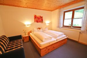 a bedroom with a bed and a chair and a window at Haus Plattenkar in Obertauern