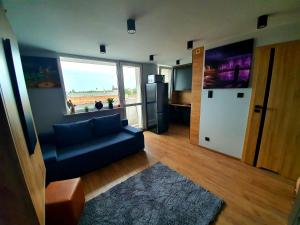 a living room with a blue couch and a refrigerator at Apartament P&P Prestige in Inowrocław