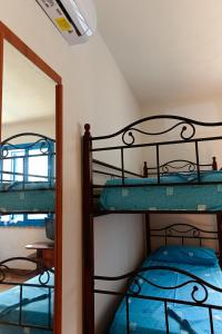 Vivi Marettimo في ماريتيمو: غرفة نوم مع سريرين بطابقين ومرآة