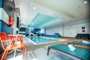 a swimming pool in a room with orange chairs at Tru By Hilton Yarmouth, Ns in Yarmouth