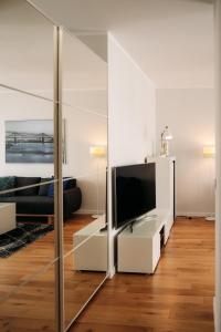 - un salon avec une télévision et un miroir dans l'établissement Apartament 15, à Kościerzyna