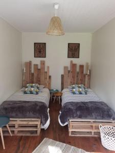 a bedroom with two beds and a chandelier at A la croisée des chemins in Saint-Nicolas-des-Biefs