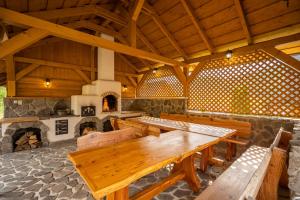 Habitación grande con mesas de madera y chimenea. en Chalet Zuberec, 5 apartments, jacuzzi, sauna, mountains en Zuberec