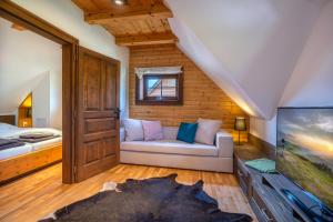 salon z kanapą i łóżkiem w obiekcie Chalet Zuberec, 5 apartments, jacuzzi, sauna, mountains w Zuberzcu