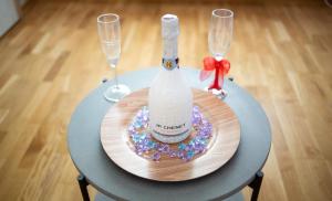 a bottle of wine on a table with two wine glasses at Diana Sunshine Apartment in Tulcea