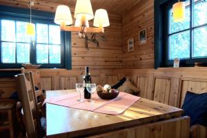 a wooden table with a bottle of wine and a bowl of fruit at Galå Fjällgård in Galåbodarna +20 photos