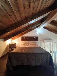 a bedroom with a large bed and a wooden ceiling at La sosta di Silla in Squille