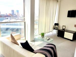 a living room with a white couch and a large window at Cityscape Apartment in Birmingham with Self Checkin in Birmingham
