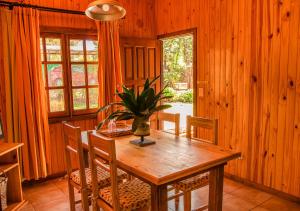 uma sala de jantar com uma mesa de madeira e uma planta em El Descanso Iguazú by DOT Cabana em Puerto Iguazú