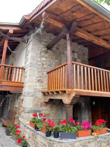 a wooden deck on the side of a building with flowers at LA CASINA DE PAULA in Ríoseco