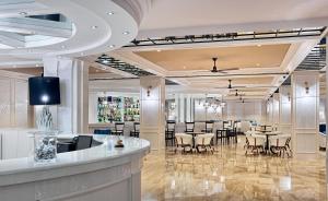 a lobby with a bar and tables and chairs at H10 Delfín - Adults Only in Salou
