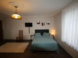1 dormitorio con 1 cama, 1 silla y TV en Gîte Étival-Clairefontaine, 3 pièces, 5 personnes - FR-1-589-379, en Étival-Clairefontaine