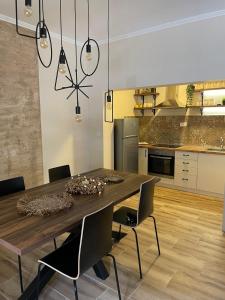 eine Küche mit einem Esstisch aus Holz und Stühlen in der Unterkunft Apartman EVA in Bajina Bašta