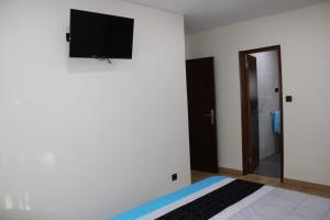 - une chambre avec un lit et une télévision murale à écran plat dans l'établissement APARTAMENTO CIDADE NOVA, à Viana do Castelo