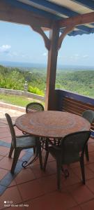 a table and chairs sitting on a porch with a view at Concept Kreyol in Sainte-Rose
