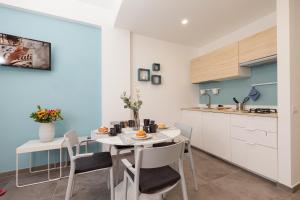 uma cozinha e sala de jantar com mesa e cadeiras em Nerissa suites&rooms em Terrasini