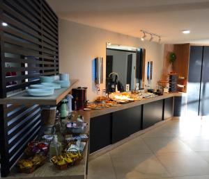 a kitchen with a counter with a sink and a mirror at Cegil Hotel Boulevard in Resende