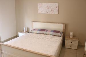 um pequeno quarto com uma cama e uma fotografia na parede em CasaVera apartment em Acireale