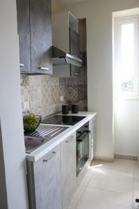 uma cozinha com fogão forno superior ao lado de uma janela em CasaVera apartment em Acireale