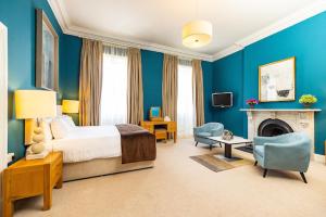 a blue bedroom with a bed and a fireplace at Butler House in Kilkenny