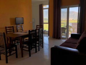 a living room with a table and chairs and a television at Rainbow Holiday Apartments in Vlorë