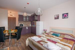 a bedroom with a bed and a table and a kitchen at Admiral Plaza Holiday Apartments in Sunny Beach