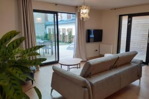 sala de estar con sofá y TV en Villa N°5, en Blonville-sur-Mer