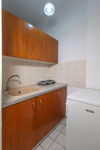 a kitchen with wooden cabinets and a sink at Galini apartments Polyhrono in Kassandria