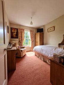 Un dormitorio con una cama y un sofá y una ventana. en The Old Vicarage, en Shrewsbury