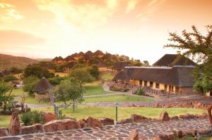 una casa con techo de paja en un campo verde en Hannah Game Lodge, en Ohrigstad