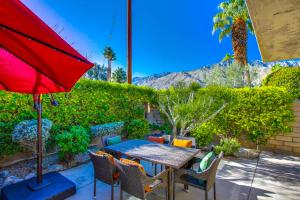 a table with chairs and a red umbrella on a patio at Sagewood Vacation Condo in Palm Springs