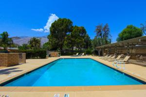 a swimming pool with lounge chairs in a resort at Sagewood Vacation Condo in Palm Springs