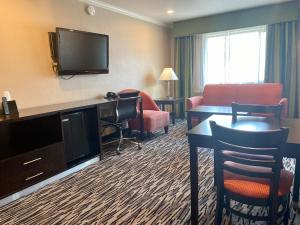 a hotel room with a television and a desk and chairs at Motel Capri in San Francisco