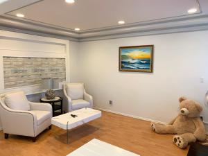 a living room with a teddy bear sitting on the floor at One Bedroom queen bed Sharing Washroom in Tiger Sweet House License## in Richmond