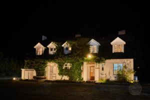 a house with ivy on the side of it at night at Casona Belga Hotel Boutique y Restaurante in Chile Chico