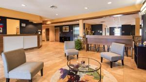 a lobby with chairs and a table and a bar at SureStay Plus Hotel by Best Western Keyser in Keyser