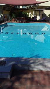 a large swimming pool with blue water at Jackaroo Motel in Mareeba