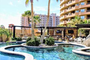 una piscina en un complejo con palmeras en Bella Sirena Luxury Resort 205-D en Puerto Peñasco
