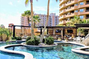 a pool at a resort with palm trees at Bella Sirena Luxury Resort 205-D in Puerto Peñasco