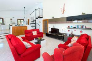 a living room with red chairs and a red couch at Can Brenno in Port de Pollensa