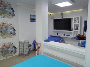 a living room with a large tv and a room with at Delfin 207 in Cartagena de Indias