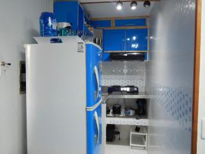 a kitchen with blue cabinets and a white refrigerator at Delfin 207 in Cartagena de Indias