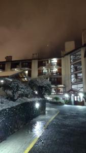 an empty parking lot in front of a building at night at Residencial Pousada do Serrano in Gramado