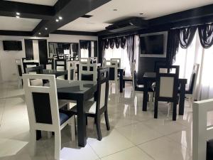 a dining room with black and white tables and chairs at Hotel Villa Tournon in San José