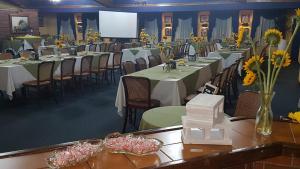 una sala de conferencias con mesas, sillas y una pantalla en Hotel Villa Tournon, en San José